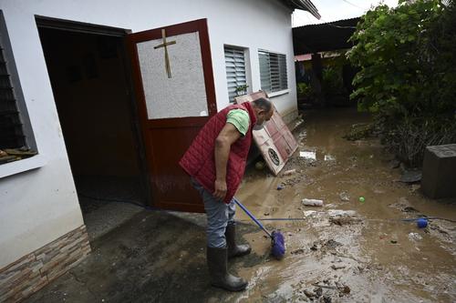 Un hombre limpia el interior de una casa que fue afectada por las inundaciones tras el paso de Eta por Guatemala. (Foto: AFP)
