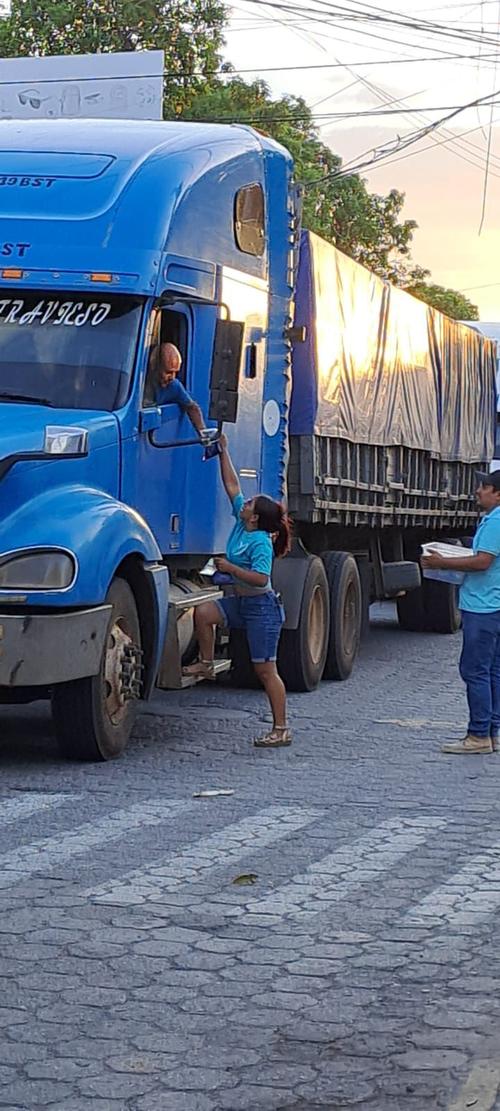 Una pobladora de las áreas por donde se movilizó el transporte pesado para rodear el puente Güijo, apoya a uno de los pilotos. (Foto: Cortesía/Soy502)