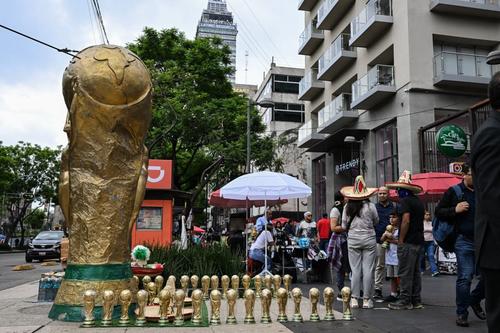Vendedores exhiben recuerdos con la forma del trofeo de la Copa Mundial en una calle de la Ciudad de México.