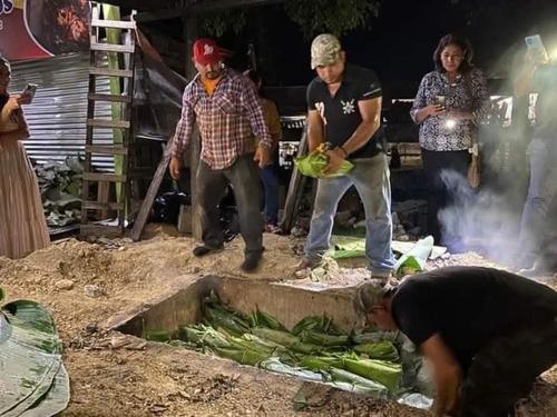 Familias preparan la tradicional barbacoa bajo tierra. (Foto: Noticias de Petén)
