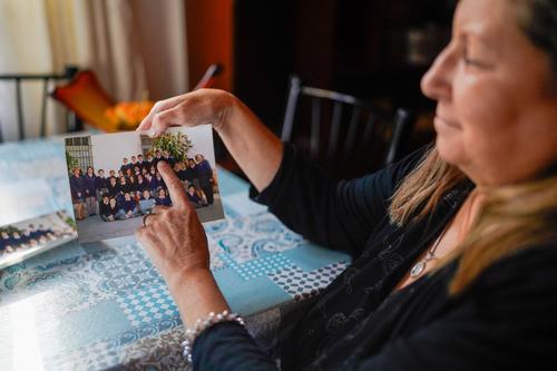 La maestra argentina Alejandra León posa para una foto mientras sostiene una fotografía escolar de Emiliano Martínez, durante una entrevista con la AFP en su casa en Mar del Plata. (Foto: AFP)