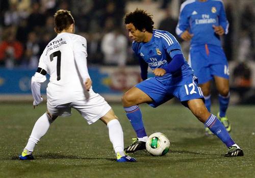 El defensa brasileño del Real Madrid, Marcelo (derecha), intenta superar al jugador del Olimpic, Denis, durante el encuentro correspondiente a la ida de los dieciseisavos de final de la Copa del Rey, que han disputado esta noche en el estadio La Murta de la localidad valenciana. (EFE)