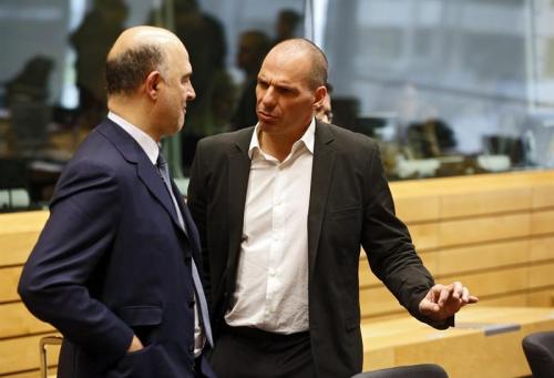 El ministro de Finanzas griego, Yanis Varufakis (c), conversa con el comisario europeo de Economía y Asuntos Financieros, Pierre Moscovici (izq), al inicio de una reunión de los ministros de Finanzas de la Unión Europea sobre Grecia en Bruselas (Foto: EFE)