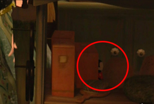 Detrás de la banca en que tropieza a Anna se ven los ojos y el traje de Mickey.