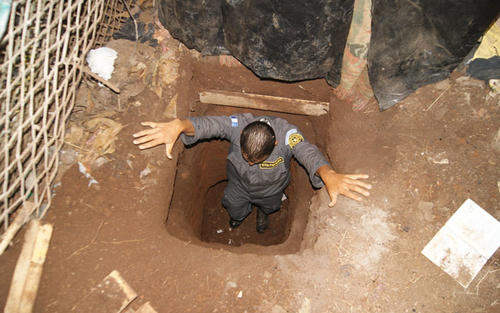 Un guardia del Sistema Penitenciario muestra la profundidad del túnel; esta se calcula en 2 metros 10. (Foto: Sistema Penitenciario)
