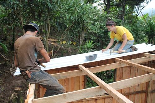 Un vecino y una voluntaria se encargan de colocar un techo
