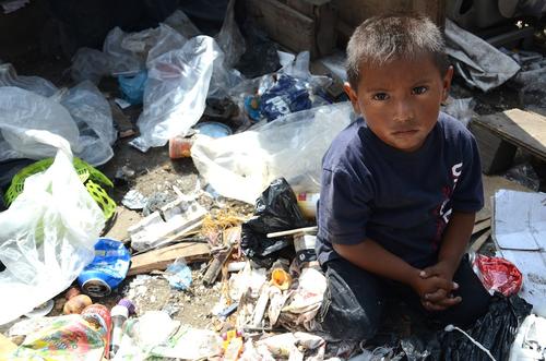 Cris es uno de los niños que trabajan en el relleno. Tiene aproximadamente 4 años, su tarea es buscar material para reciclar. El día de nuestra visita encontró algunas velas cuyo hilo y cera fue separando para poder sacar provecho de la materia prima. (Foto: Selene Mejía/Soy502)