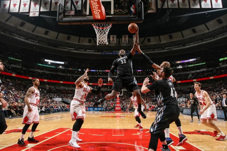 Ronny Turiaf de los Timberwolves anota ante Taj Gibson de los Bulls de Chicago. (Foto: David Sherman/AFP)