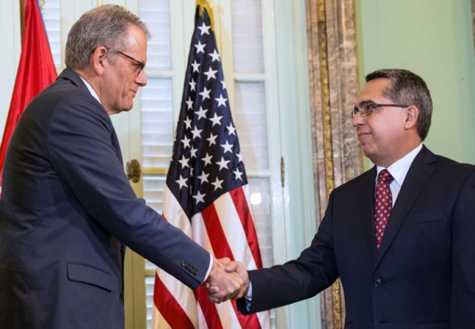 Jeffrey DeLaurentis (izquierda), saluda al vicecanciller Marcelino Medina luego de entregarle una carta del presidente Barack Obama dirigida a su homólogo Raúl Castro para abrir las embajadas en ambos países a partir del 20 de julio. (Foto: AFP)