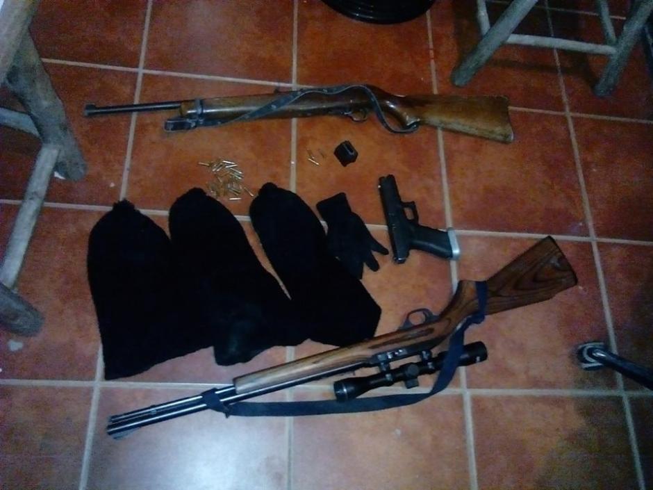 Tres gorros pasamontañas, dos rifles y una pistola les fueron decomisados a dos supuestos secuestradores que se habrían llevado a una joven de 18 años y una niña de 3 años. (Foto: Policía Nacional Civil)