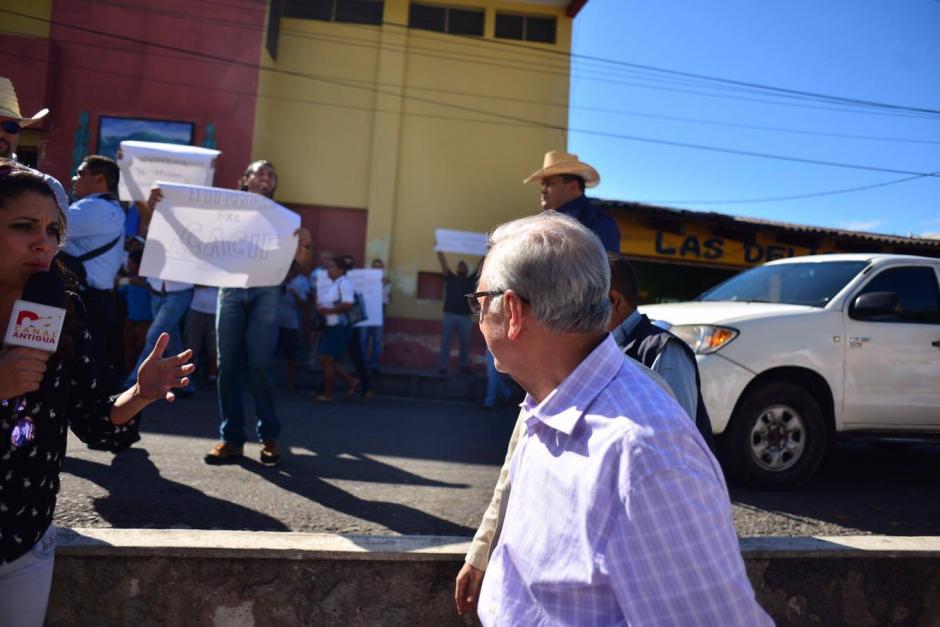El presidente Alejandro Maldonado observa los carteles que tienen escrito consignas en contra del salario mínimo diferenciado. (Foto: Jesús Alfonso/Soy502) 