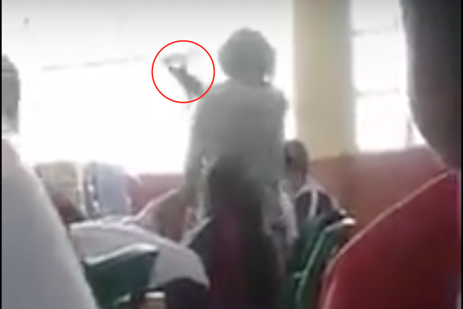 Con un cuaderno, la profesora golpea al alumno mientras lo reta a pelear a "puñetazos". (Imagen: captura de pantalla)
