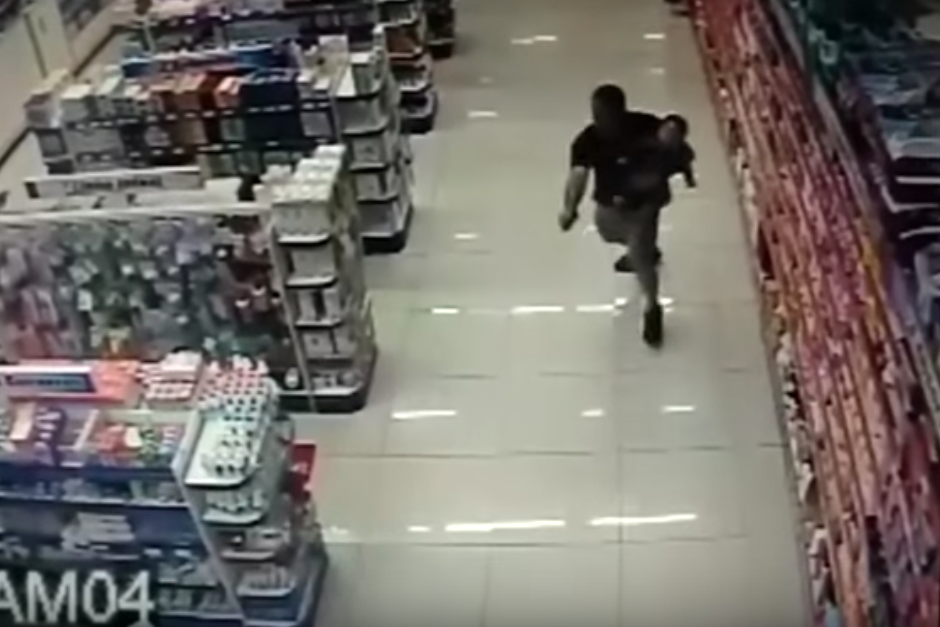 El policía desenfundó su arma con la mano derecha mientras sostenía a su bebé con la izquierda. (Imagen: captura de pantalla)