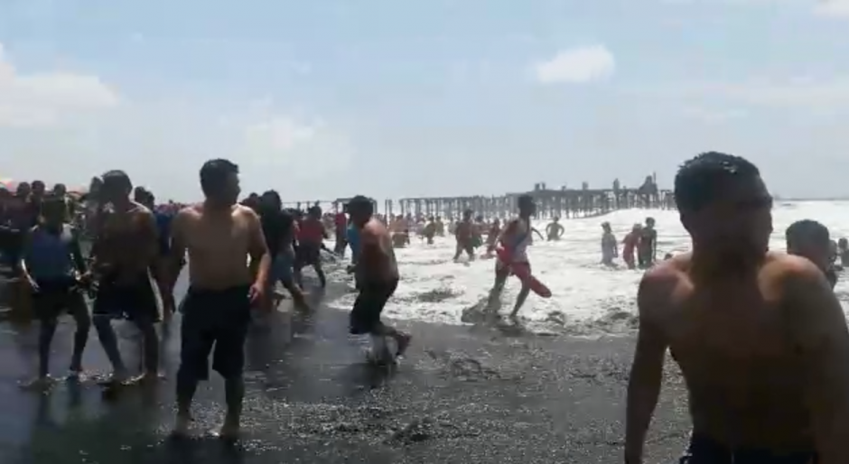 Bañistas salen del mar ante la alerta emitida por salvavidas del IGSS. 