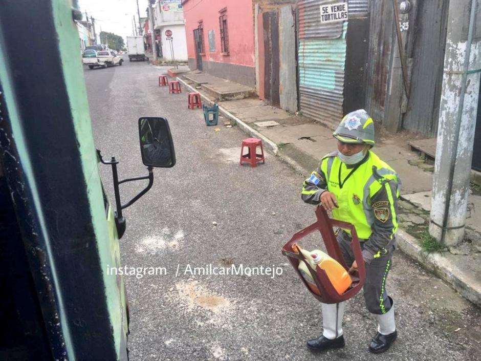 Un agente de la PMT retira objetos que utilizan para apartar parqueo en una vía libre. (Foto: Amílcar Montejo) 