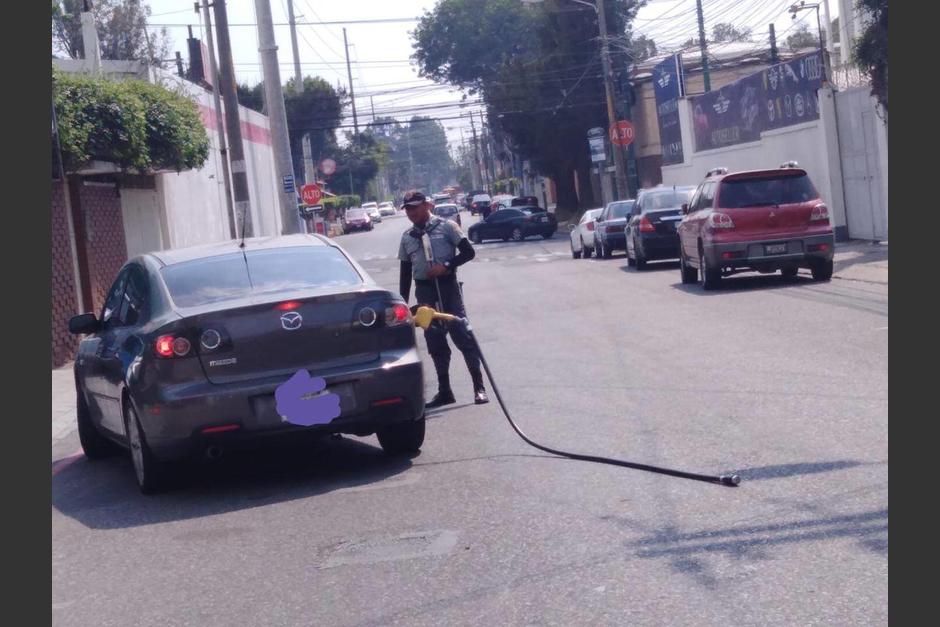 El automovilista recorrió dos cuadras sin darse cuenta que aún llevaba la manguera conectada al tanque de gasolina. (Foto: Soy502)