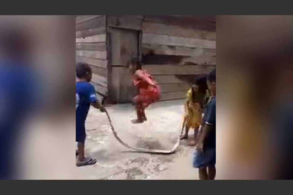 Niños saltan la cuerda con una serpiente muerta. (Foto: RT)