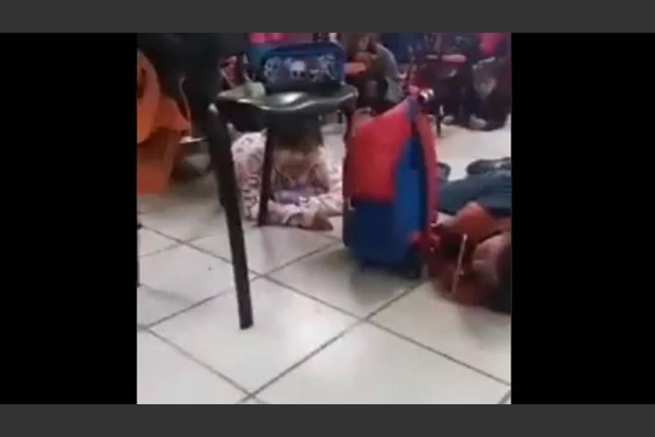 La maestra calma a los menores mientras se registra una balacera. (Foto: captura pantalla) 