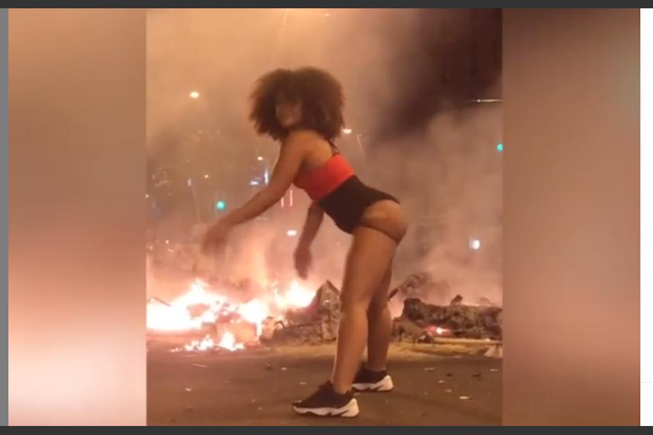 La joven baila mientras hay disturbios en Barcelona. (Foto: Captura de video)