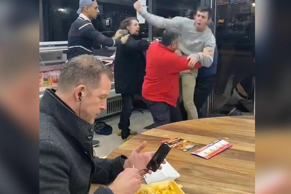 Un hombre come tranquilamente en medio de una gran pelea y se convierte en meme. (Foto: Captura de video)
