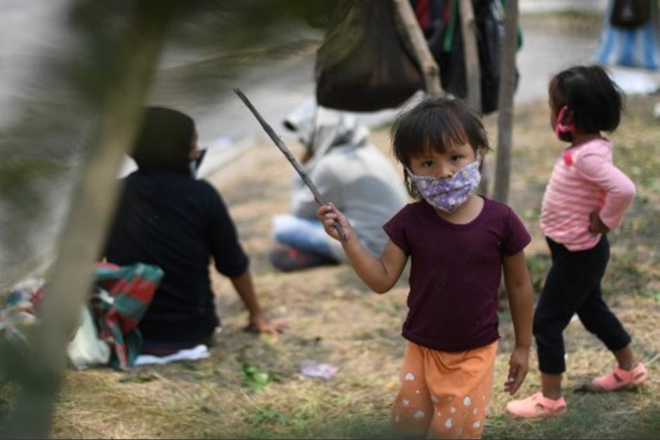 Niños juegan mientras sus padres agitan banderas blancas como señal que necesitan alimentos en un área de Villa Nueva. (Foto con fines ilustrativos/ Johan Ordóñez /AFP) 