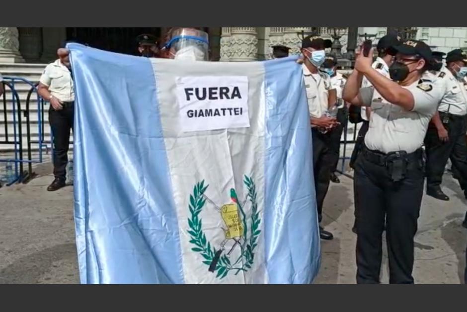 Una agente de la PNC toma fotografías a los asistentes a la Plaza. (Foto: captura de pantalla)