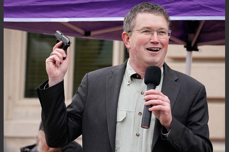 Thomas Massie en una foto de archivo de 2020 sacando una pistola de su bolsillo durante una manifestación. (Foto: AFP) 