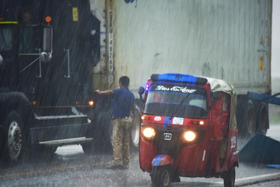 El piloto de un Tuc-Tuc fue captado bajo la lluvia dirigiendo el tráfico para evitar un accidente en Petén. (Foto: Tato Jiménez/Cortesía) 