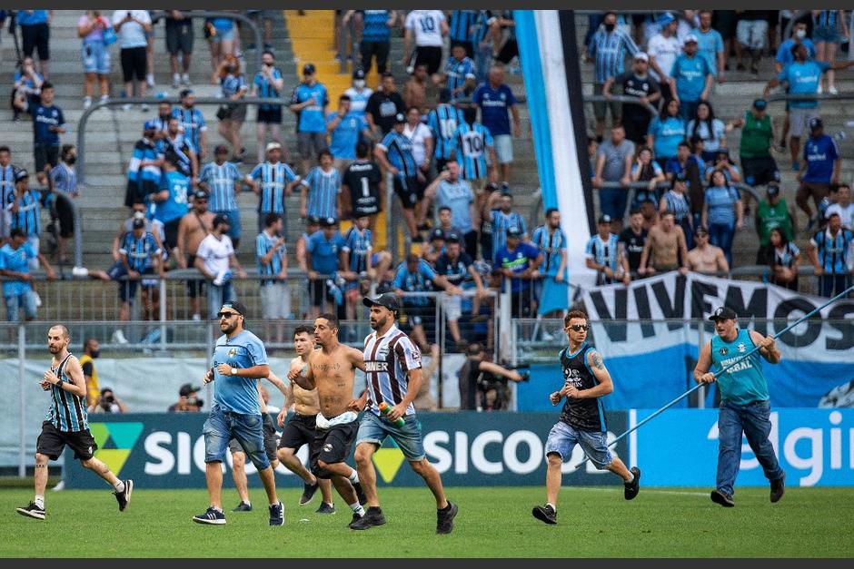 Los aficionados se enfrentaron con agentes policiales tras invadir la cancha en Brasil. (Foto: AFP)