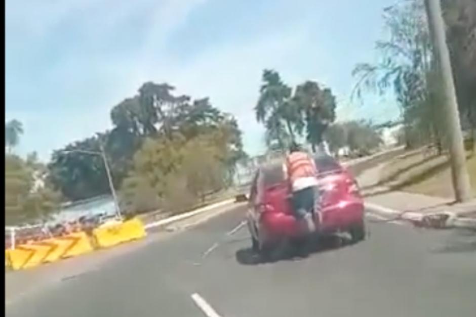 El hombre fue captado durante un trayecto en zona 13 aferrado al baúl de un vehículo. (Foto: captura de pantalla) 