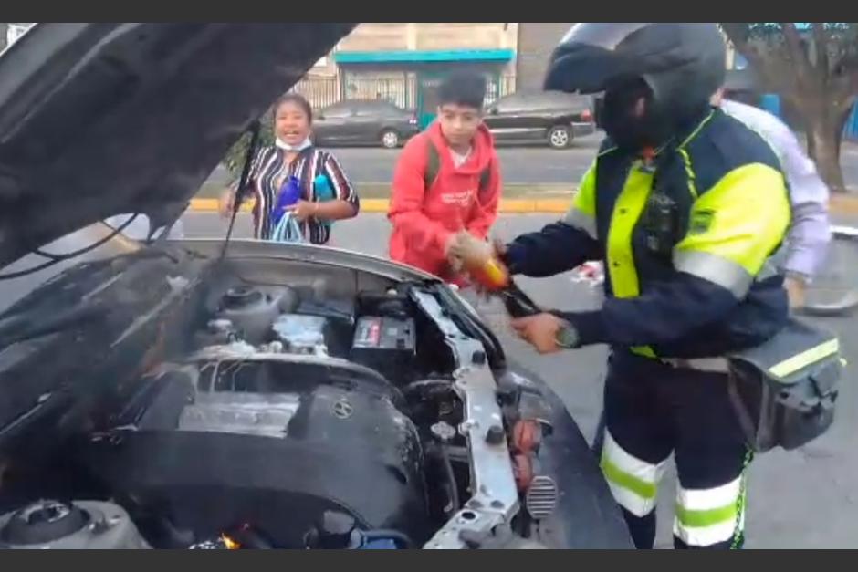 Un carro se incendió en la zona 9 y un agente de la PMT junto a otras personas sofocaron el fuego con agua gaseosa. (Foto: Amílcar Montejo)