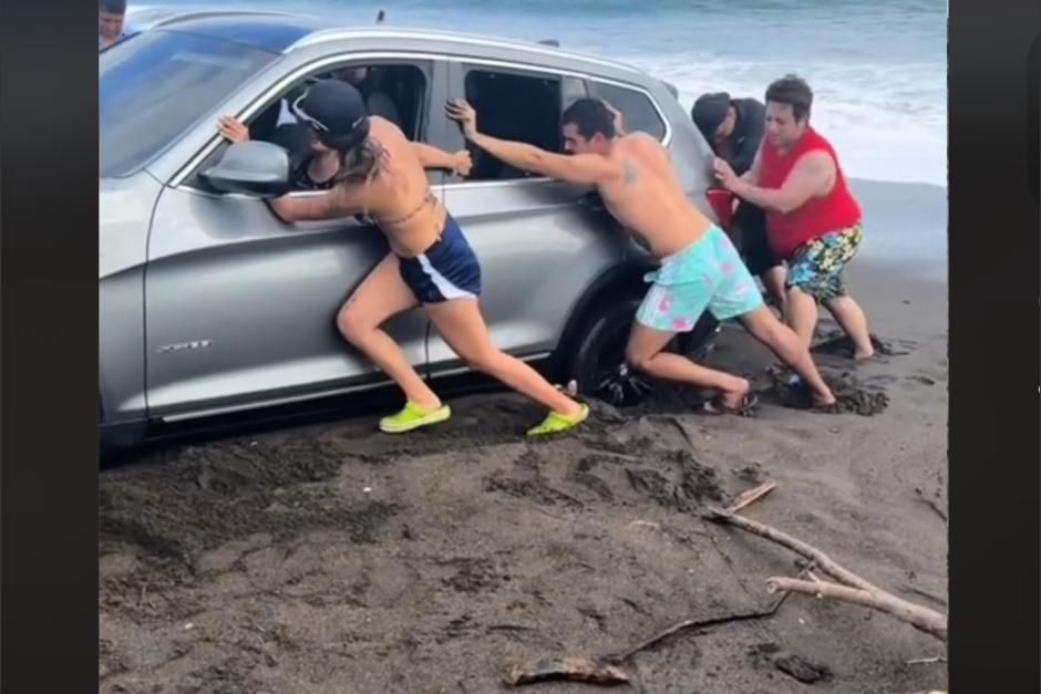 Un carro se quedó atorado a la orilla del mar en una playa guatemalteca y un grupo de personas se hizo viral en redes sociales tras intentar sacarlo del precipicio. (Foto: captura de pantalla) 