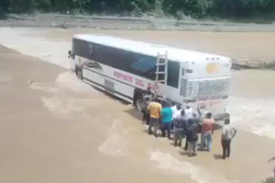 Con una escalera y entre varias personas lograron rescatar a pasajeros de un autobús en Izabal. (Foto: Captura de video)