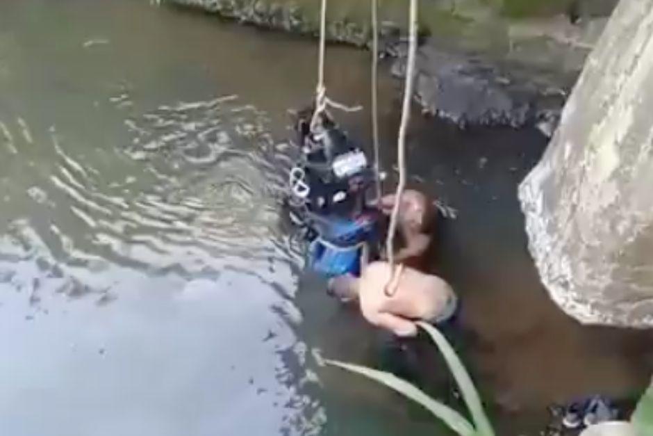 El motorista y su vehículo fueron rescatados del río tras la caída. (Foto: Captura de video)