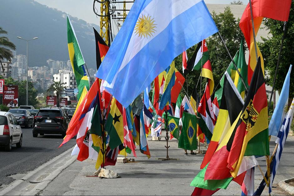 Un vendedor ambulante ofrece banderas de los países participantes en la Copa Mundial de la FIFA 2026 en la carretera principal al norte de la capital libanesa.