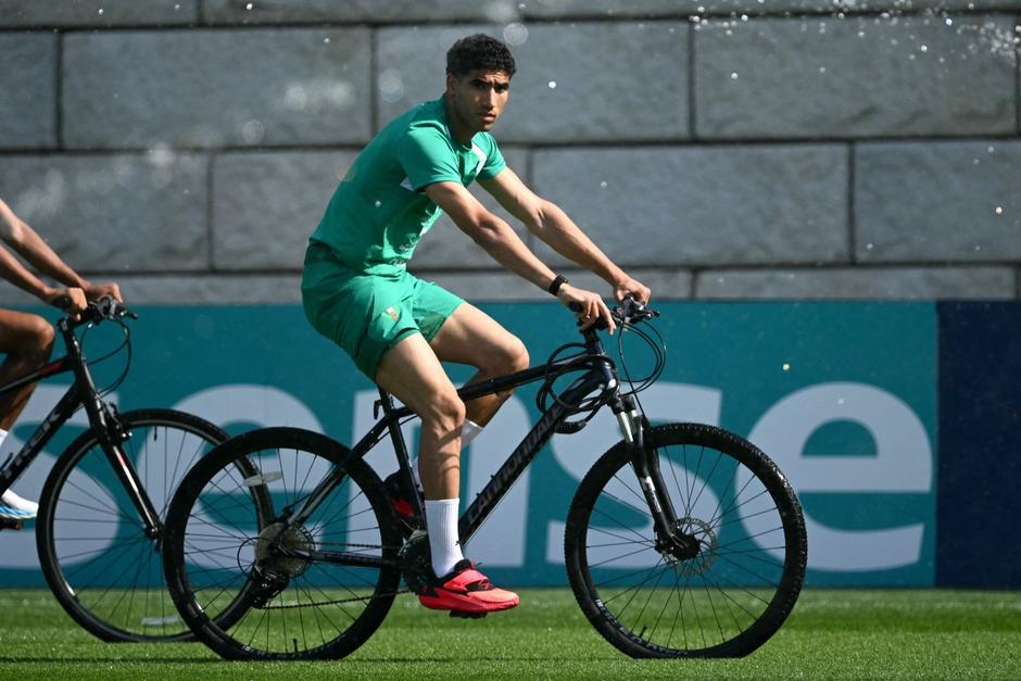 El defensa marroquí Achraf Hakimi llega en bicicleta a la sesión de entrenamiento de Marruecos, en Nueva Jersey. (Foto: AFP)