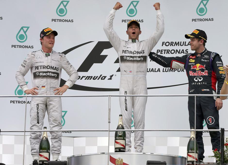 El piloto británico de Fórmula Uno, Lewis Hamilton, celebra el triunfo conseguido hoy en Sepang, junto a Nico Rosberg y Sebastian Vettel . (Foto: EFE)