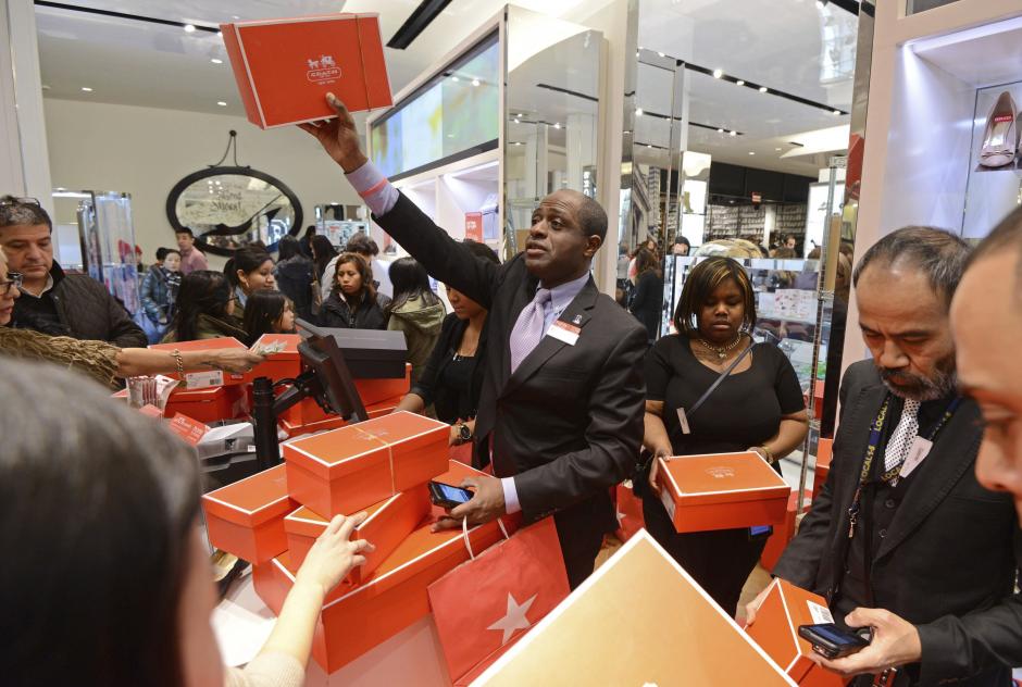 Un vendedor intenta acercar su compra a un cliente mientras una multitud de clientes visitan los grandes almacenes Macy's la noche de Acción de Gracias en Nueva York (Estados Unidos) el 28 de noviembre de 2013. (Foto: EFE/Peter Foley)