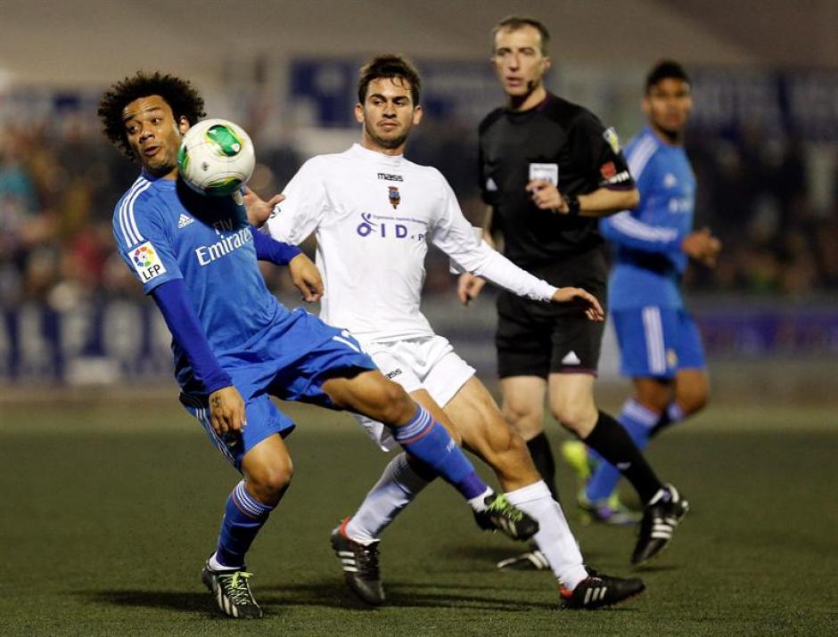 El defensa brasileño del Real Madrid, Marcelo (izquierda), controla el balón ante el jugador del Olimpic, durante el encuentro correspondiente a la ida de los dieciseisavos de final de la Copa del Rey, que han disputado esta noche en el estadio La Murta de la localidad valenciana. (EFE)