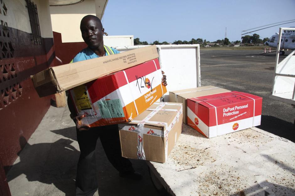 Un hombre liberiano descarga equipo de protección y otros materiales para combatir el virus del ébola. (Foto:Efe) 