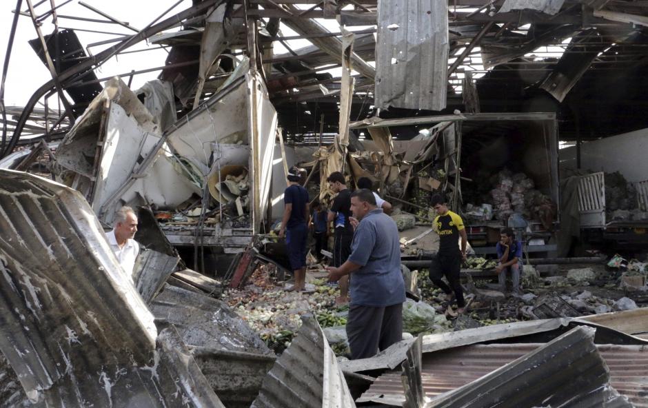 Varias personas caminan entre los escombros después de un atentado en un mercado en Bagdad. (Foto: EFE)