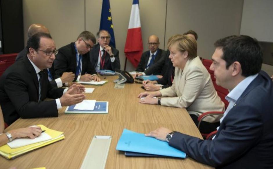 Tsipras, reunido con Merkel y Holland, la mañana del 26 de junio en la cumbre de jefes de estado y de gobierno de la Unión Europea en Bélgica. (Foto: EFE)