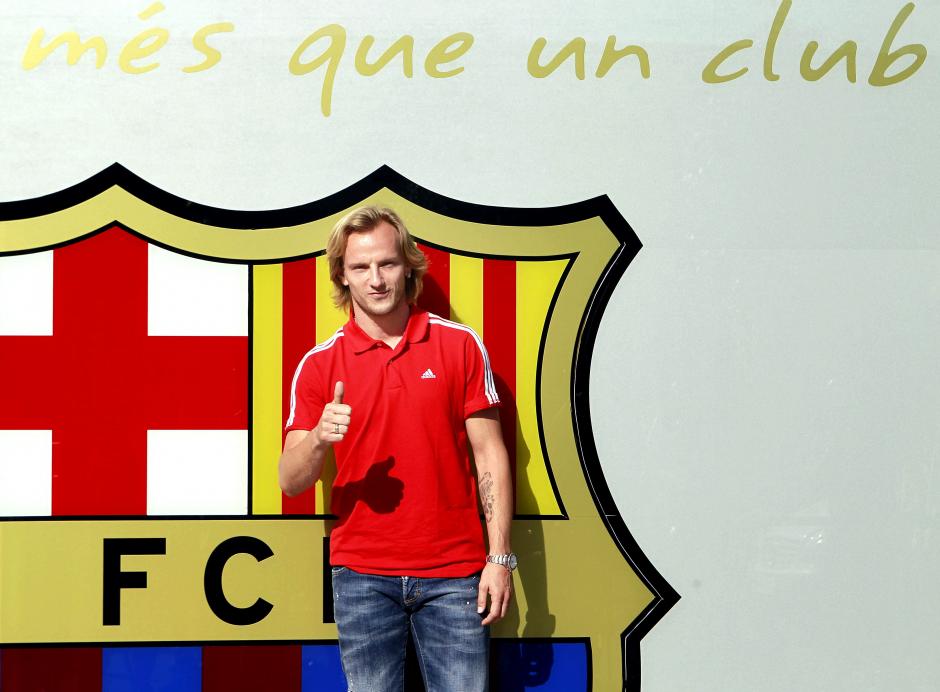 El centrocampista croata Ivan Rakitic posa este día junto al escudo que preside la entrada de las oficinas del FC Barcelona, con lo que formaliza su primer acto como jugador azulgrana después de despedirse del Sevilla en una emotiva rueda de prensa esta mañana. El centrocampista croata será presentado mañana como nuevo jugador del Barça en una maratoniana jornada. (Foto: EFE)