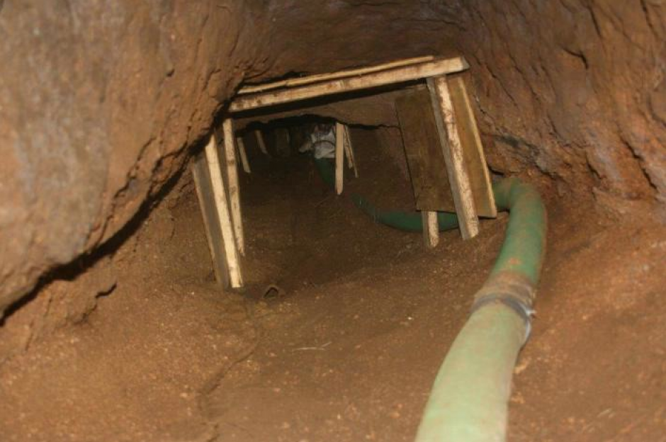 El túnel en construcción estaba sujeto por vigas de madera y tenía una manguera de respiración. 