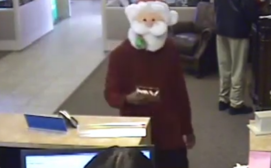 El ladrón lleva los bastones de caramelo en las manos para repartirlos entre los clientes y empleados del banco. (Imagen: captura de pantalla)