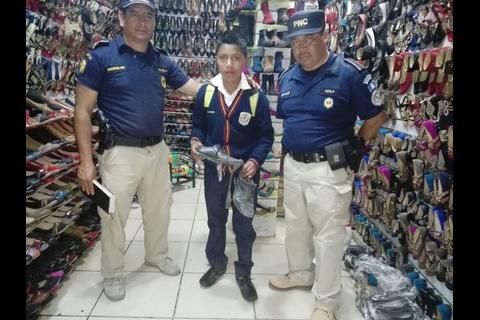 Agentes de policía le compran zapatos a un niño en Chichicastenango