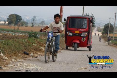 Niño apasionado por el ciclismo compite con botas de hule