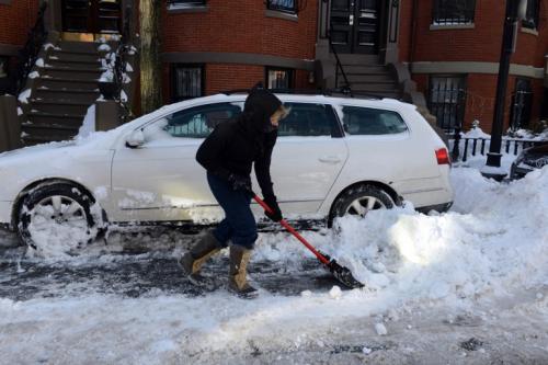 Una mujer quita la nieve de su carro con una pala en Concord Street East, Massachusetts. La tormenta comenz&oacute; a mediod&iacute;a el jueves con fuertes nevadas durante la noche hasta el viernes. (AFP)