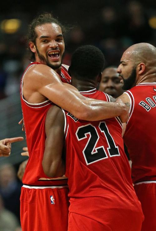 Joakim Noah y Carlos Boozer de los Bulls de Chicago, celebran junto a Jimmy Butler durante el juego ante los Nets de Brooklyn