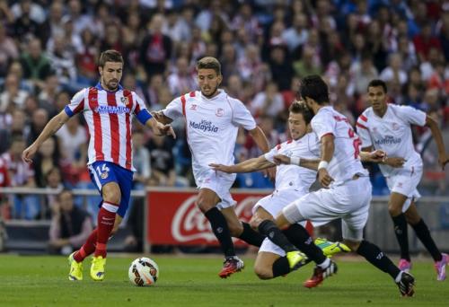 Gabriel Fern&aacute;ndez conduce el bal&oacute;n ante la marca de los defensores de Sevilla. (Foto: EFE)